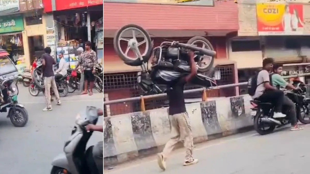 Hapur youth walks on busy road carrying bike on shoulder for reel