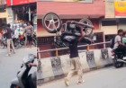 Hapur youth walks on busy road carrying bike on shoulder for reel